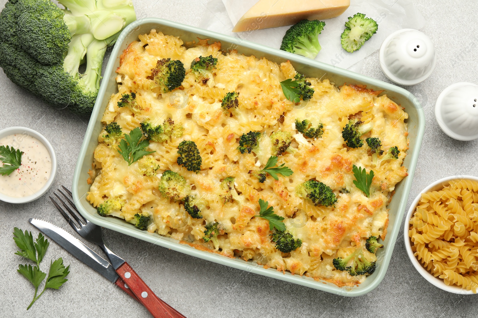 Photo of Tasty pasta casserole with cheese and broccoli served on grey table, flat lay