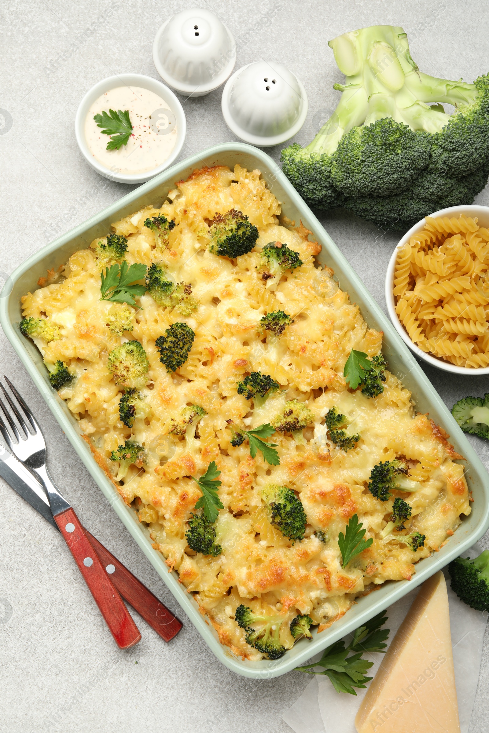 Photo of Tasty pasta casserole with cheese and broccoli served on grey table, flat lay