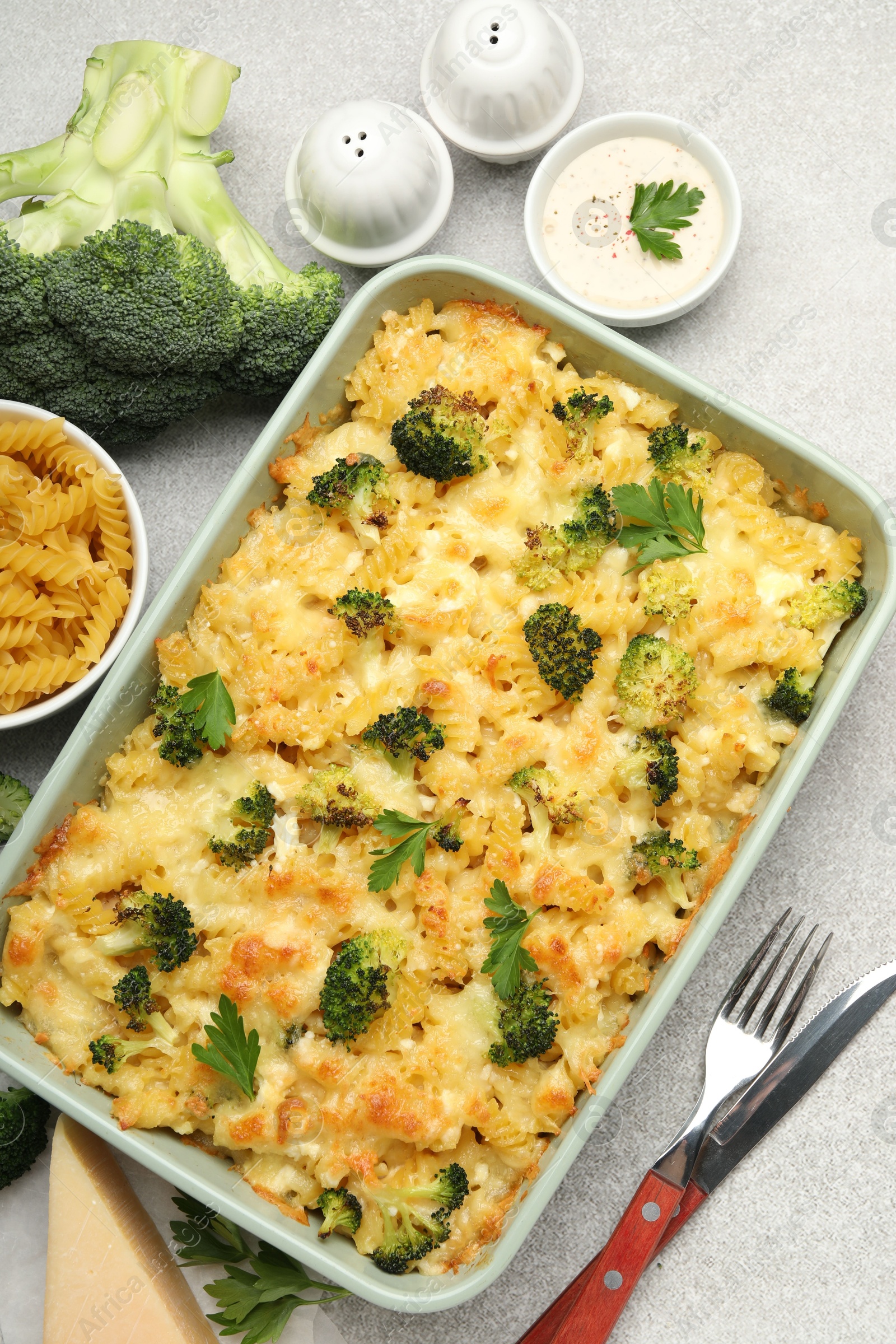 Photo of Tasty pasta casserole with cheese and broccoli served on grey table, flat lay