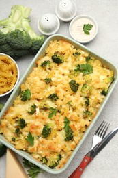 Photo of Tasty pasta casserole with cheese and broccoli served on grey table, flat lay