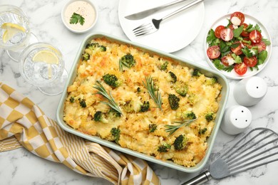 Photo of Tasty pasta casserole with cheese and broccoli served on white marble table, flat lay