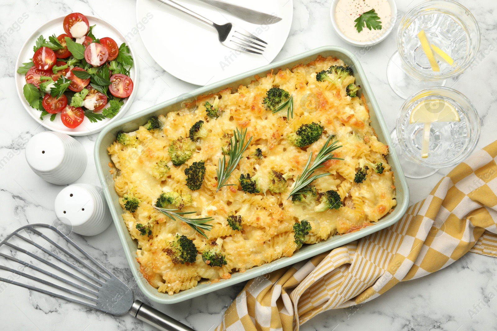 Photo of Tasty pasta casserole with cheese and broccoli served on white marble table, flat lay