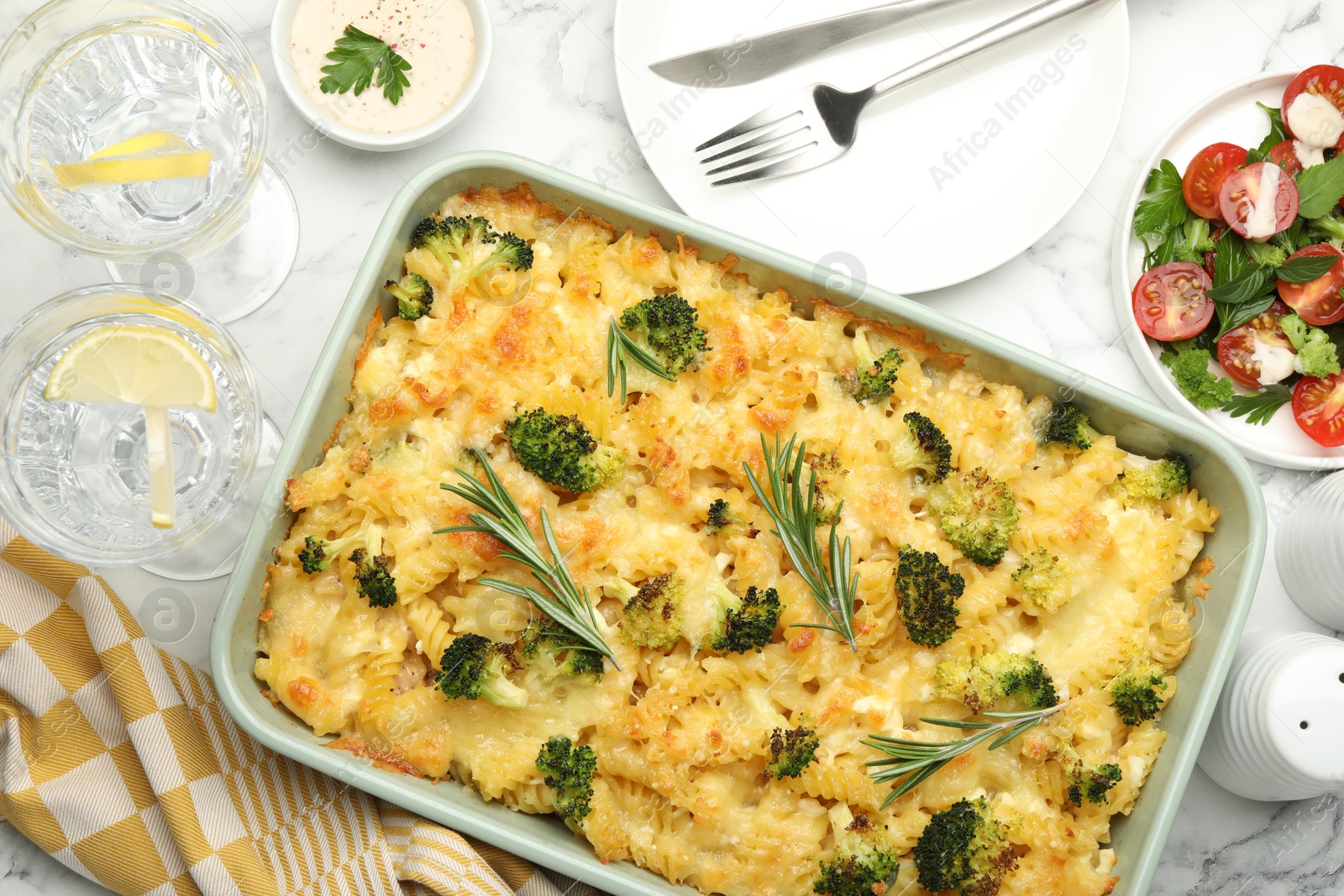 Photo of Tasty pasta casserole with cheese and broccoli served on white marble table, flat lay