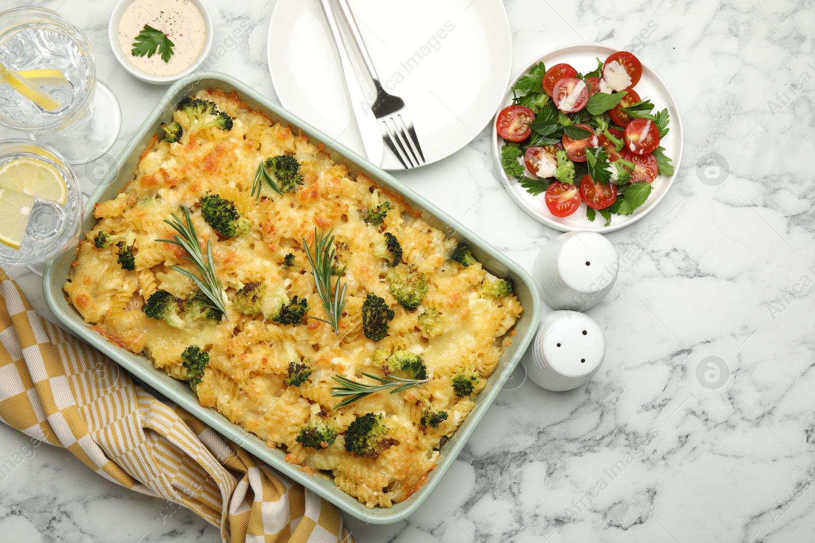 Photo of Tasty pasta casserole with cheese and broccoli served on white marble table, flat lay. Space for text