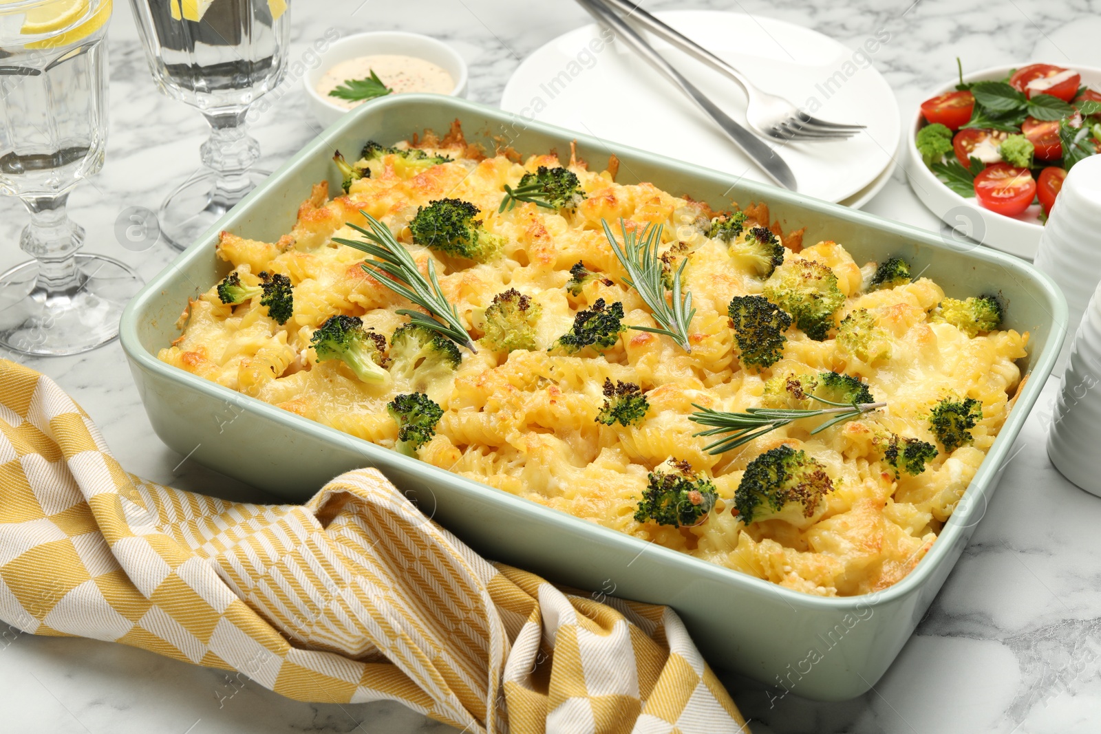 Photo of Tasty pasta casserole with cheese and broccoli served on white marble table, closeup