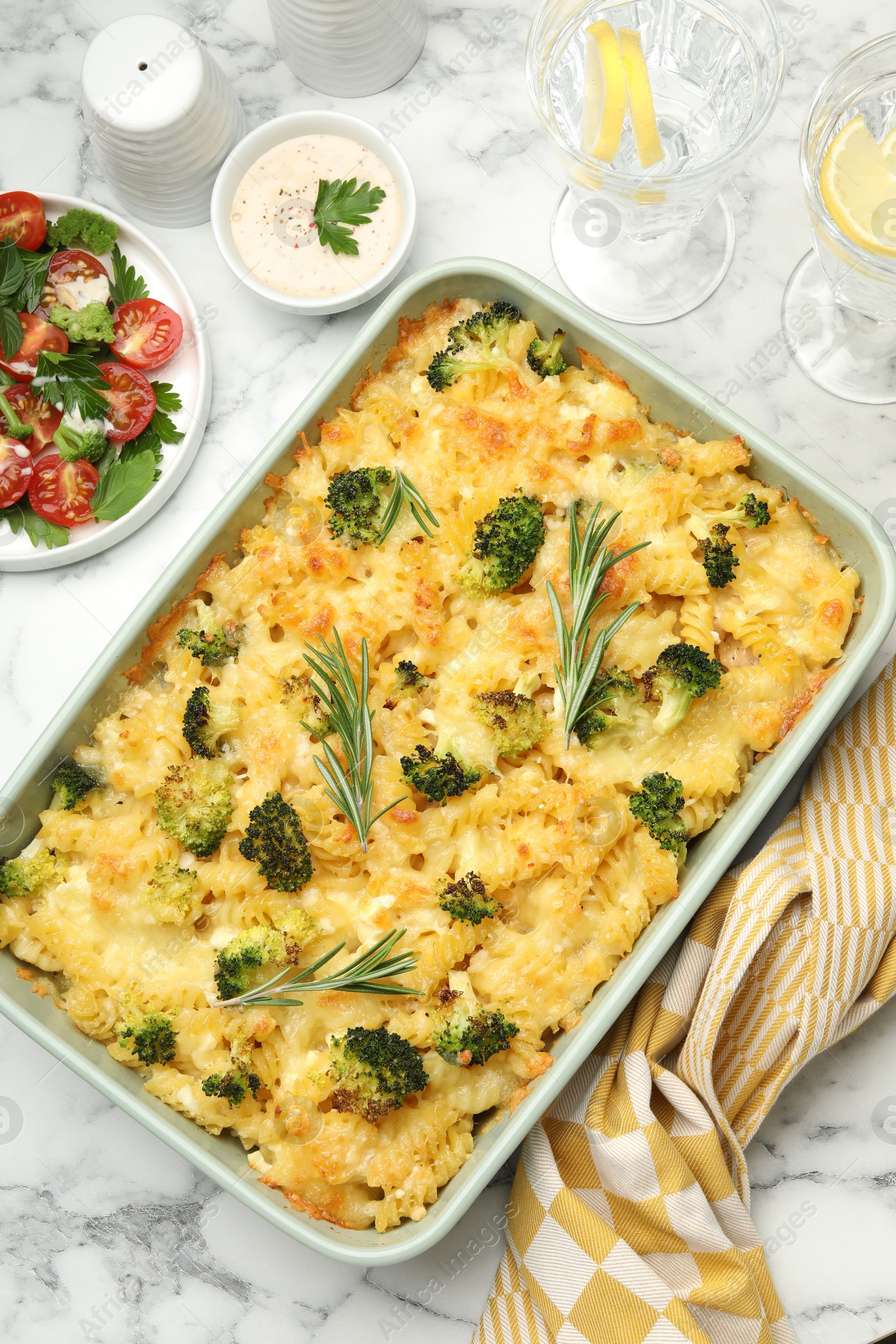 Photo of Tasty pasta casserole with cheese and broccoli served on white marble table, flat lay