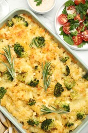 Photo of Tasty pasta casserole with cheese and broccoli served on white marble table, flat lay