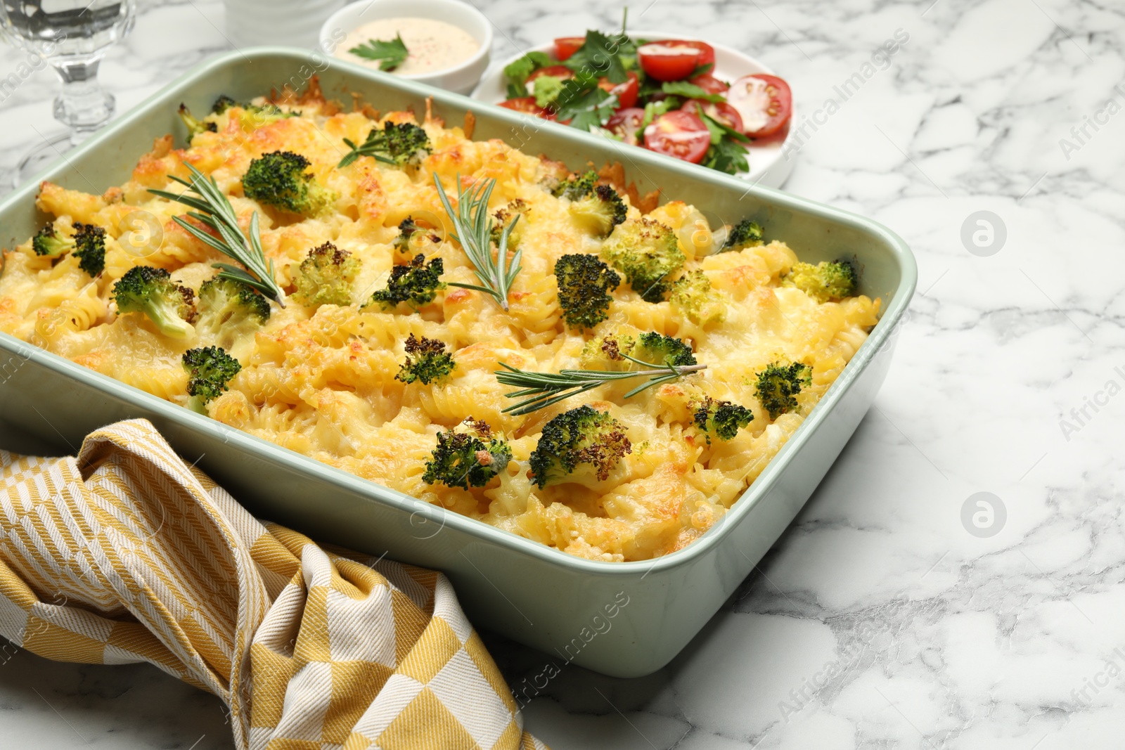 Photo of Tasty pasta casserole with cheese and broccoli served on white marble table, closeup