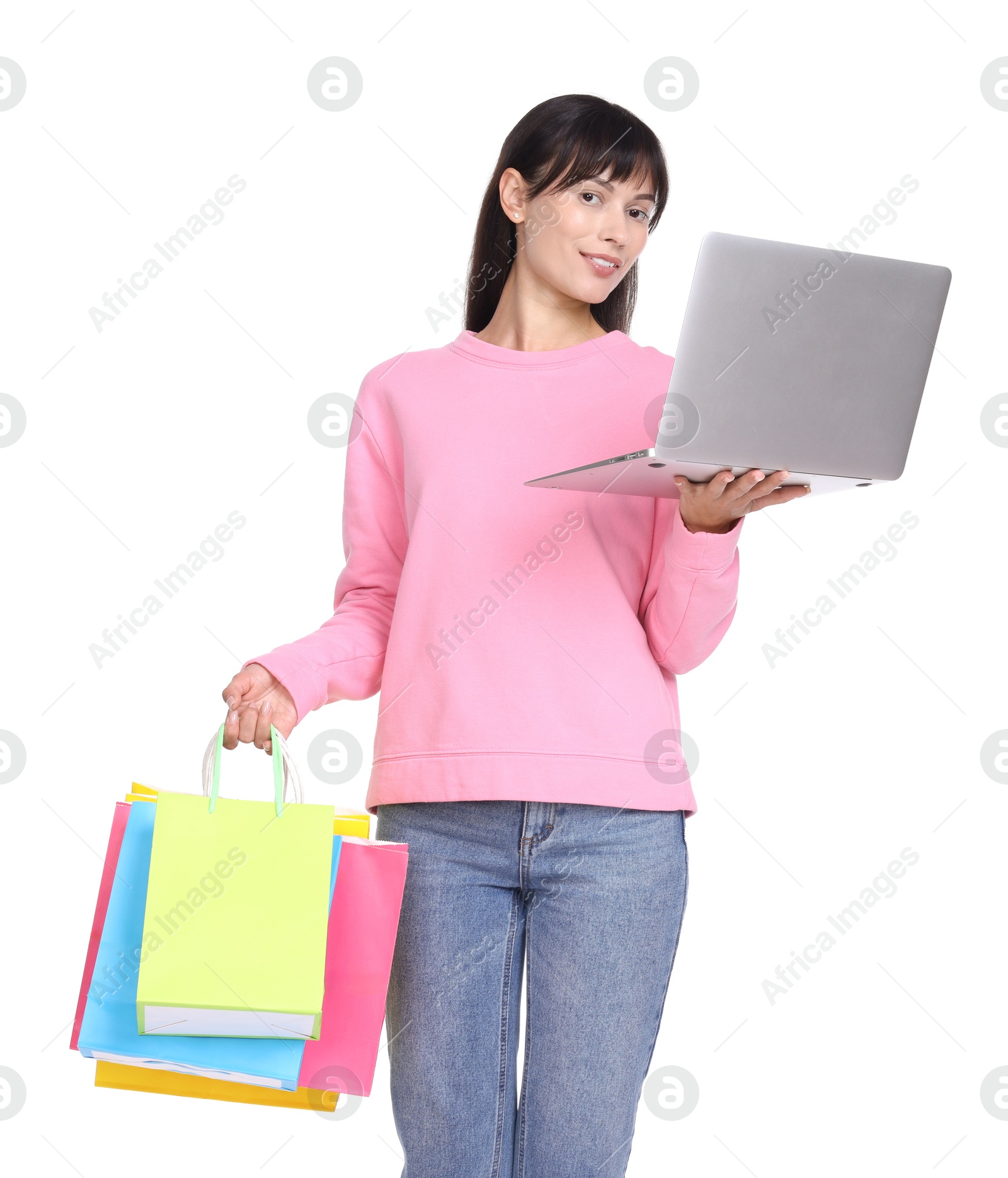 Photo of Internet shopping. Smiling woman with laptop and colorful bags on white background