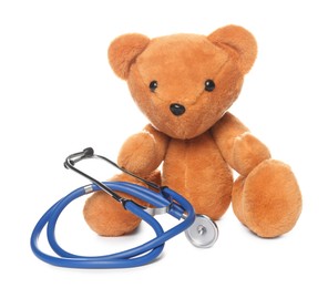 Photo of Pediatrics concept. Teddy bear and stethoscope isolated on white