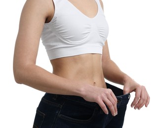 Photo of Weight loss. Woman wearing big jeans on white background, closeup