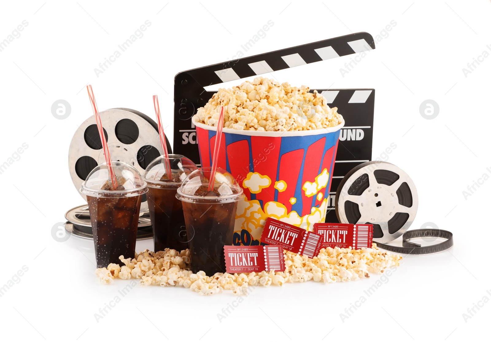 Photo of Tasty popcorn, film reels, clapper, soda drinks and movie tickets isolated on white