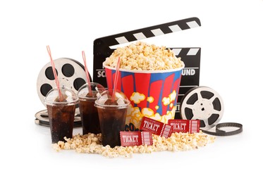 Photo of Tasty popcorn, film reels, clapper, soda drinks and movie tickets isolated on white