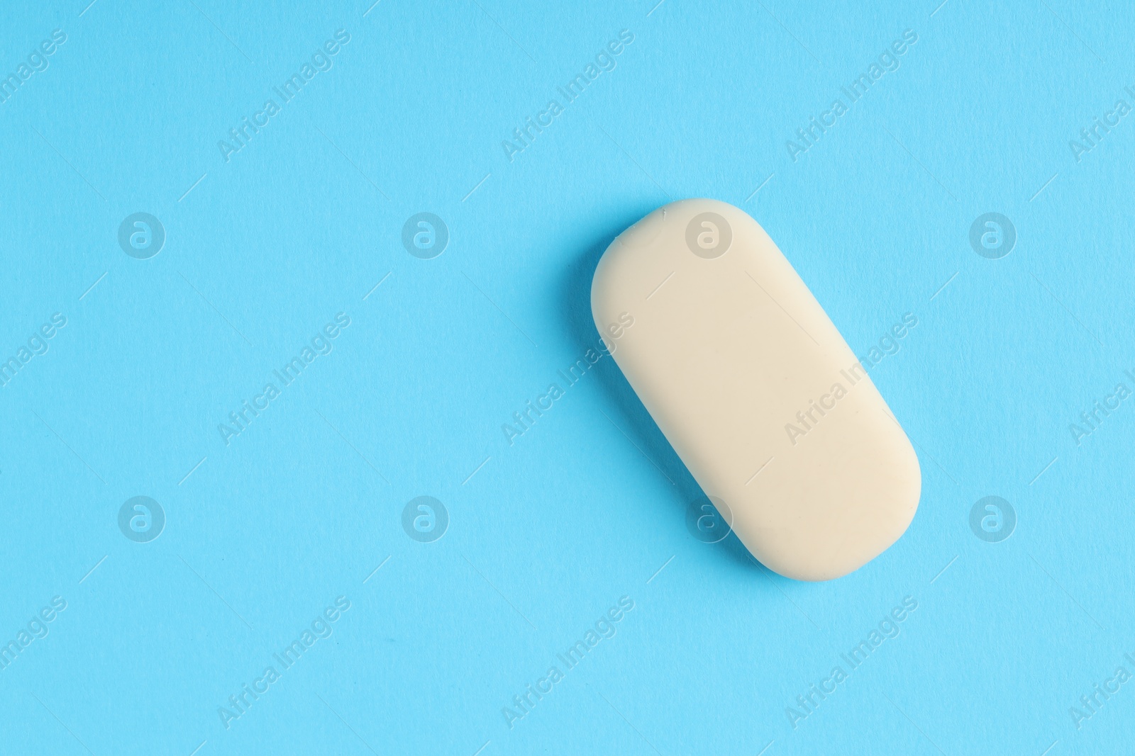 Photo of One eraser on light blue background, top view. Space for text