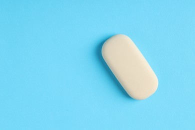 Photo of One eraser on light blue background, top view. Space for text