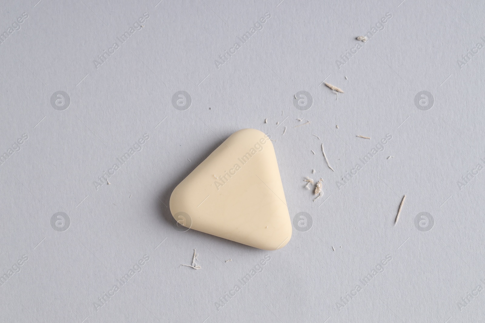 Photo of One eraser and scraps on grey background, top view