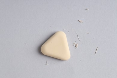 Photo of One eraser and scraps on grey background, top view