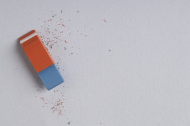 Photo of One eraser and scraps on grey background, top view. Space for text