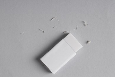 One eraser and scraps on grey background, top view