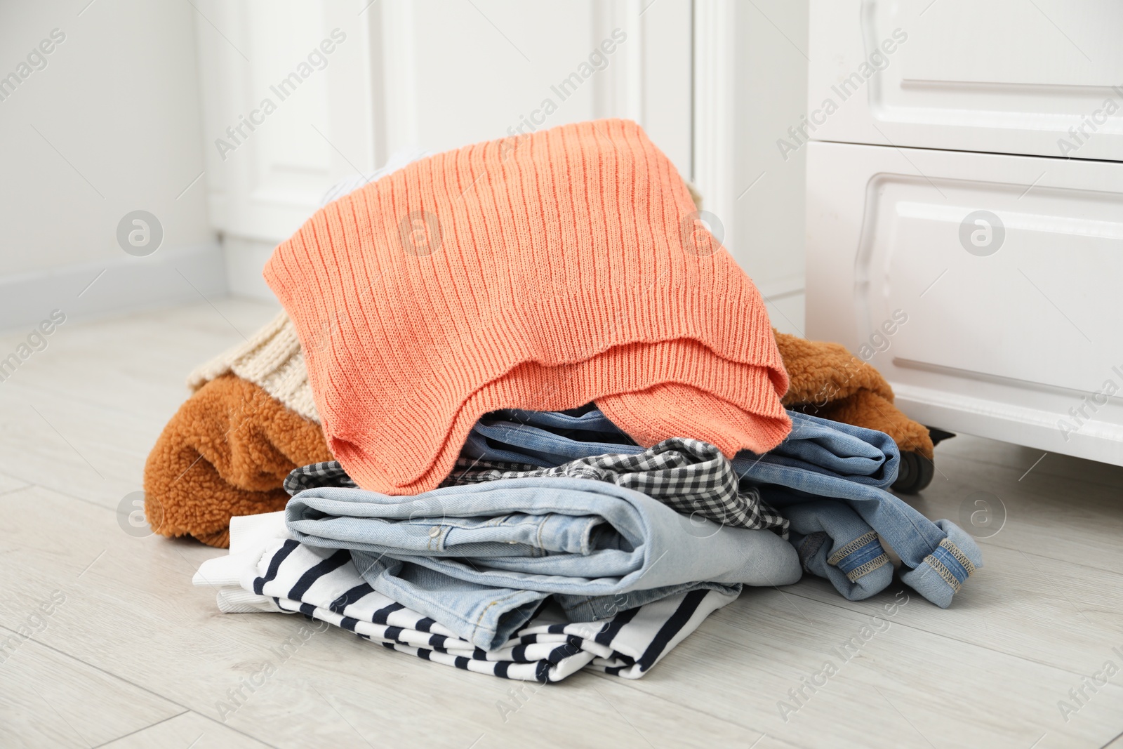 Photo of Pile of different used clothes on floor indoors