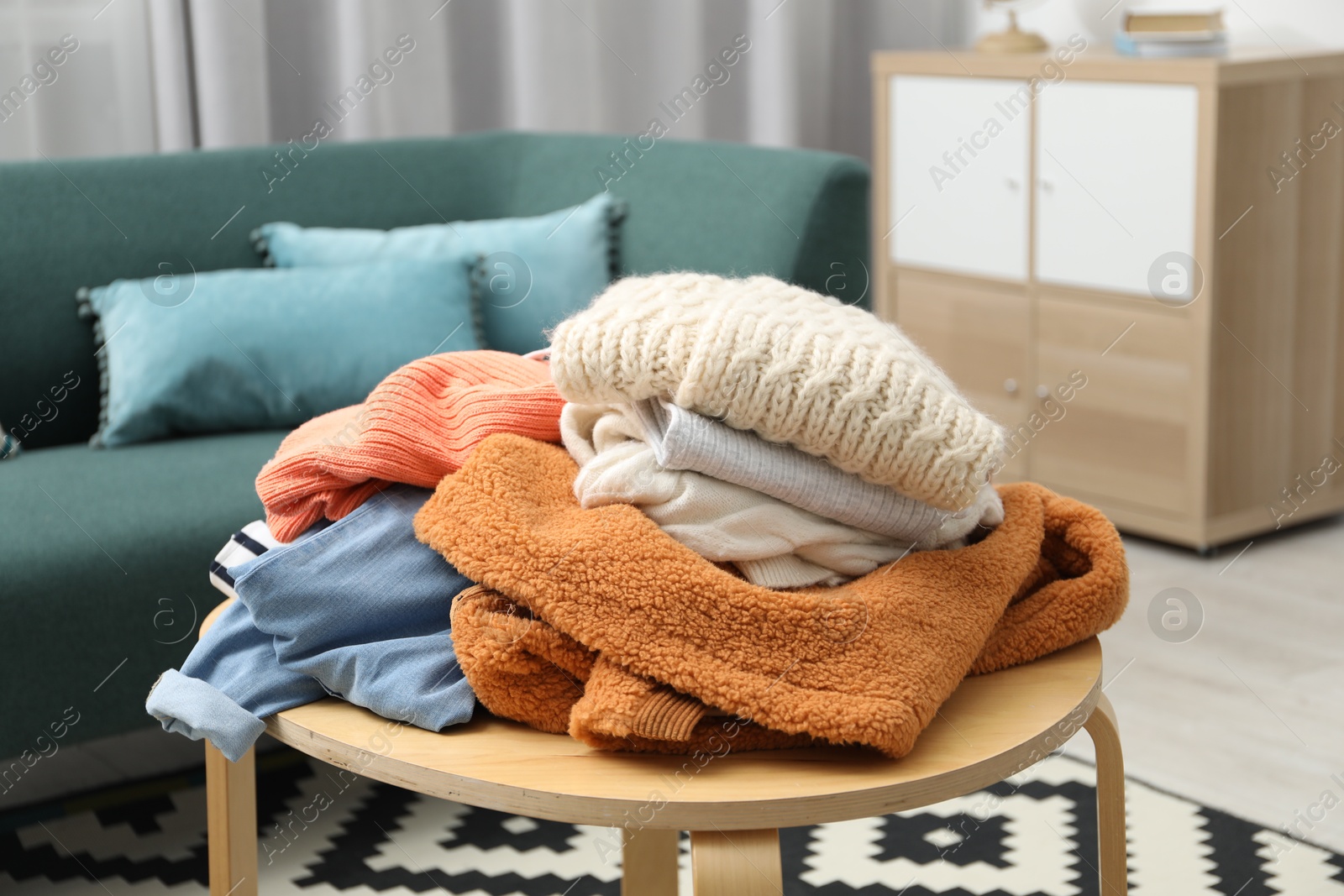 Photo of Pile of different used clothes on coffee table indoors, closeup