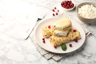 Photo of Delicious rolled crepes with cottage cheese, raisins, cranberries and mint on white marble table, space for text