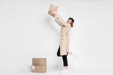 Photo of Happy postwoman with parcels on white background