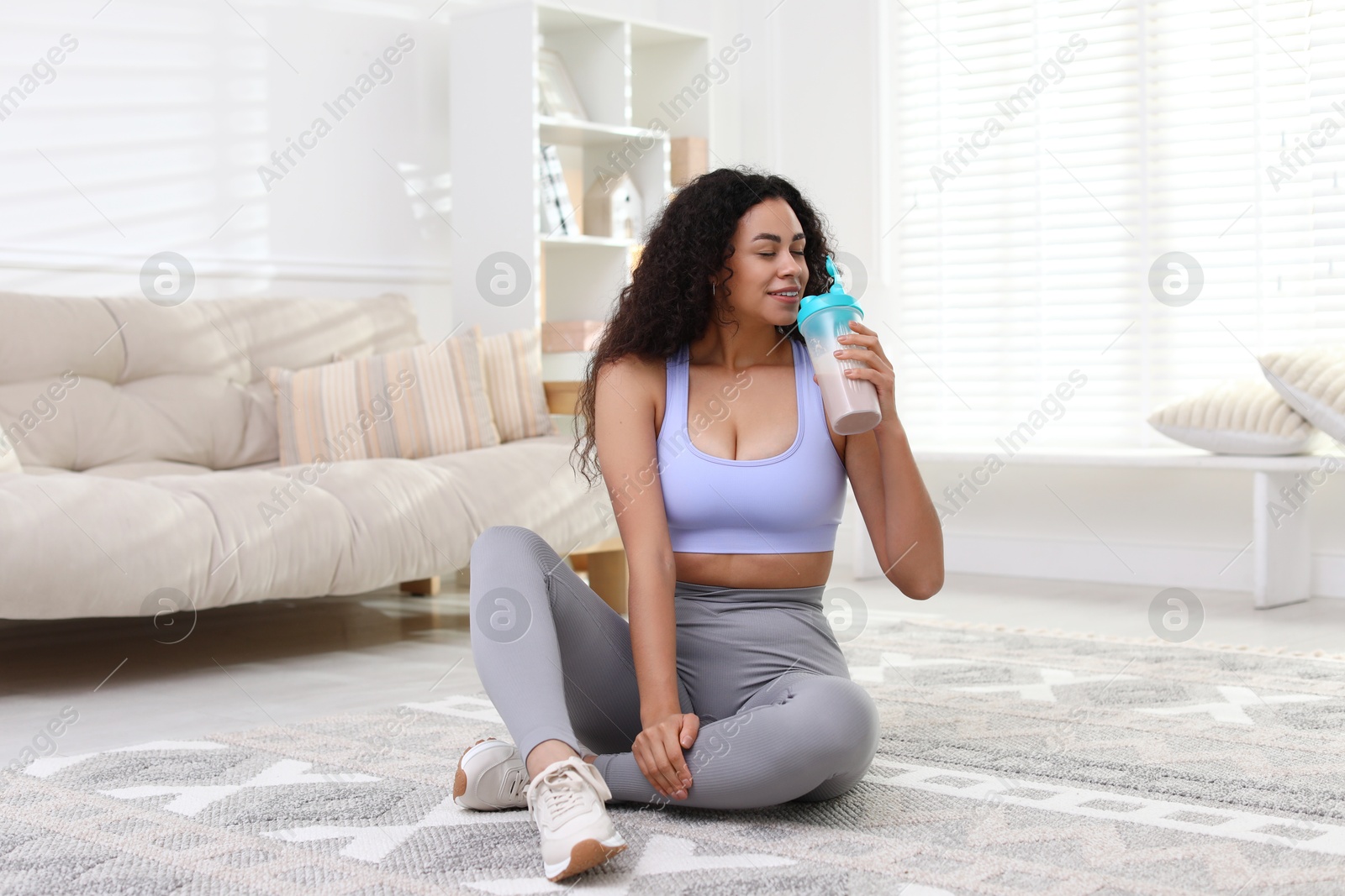 Photo of Beautiful woman drinking protein shake at home