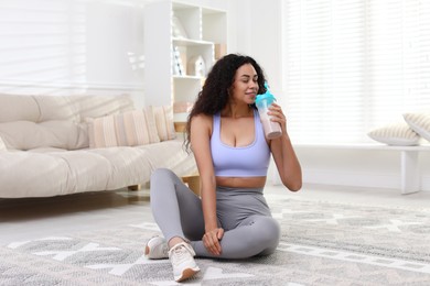 Photo of Beautiful woman drinking protein shake at home