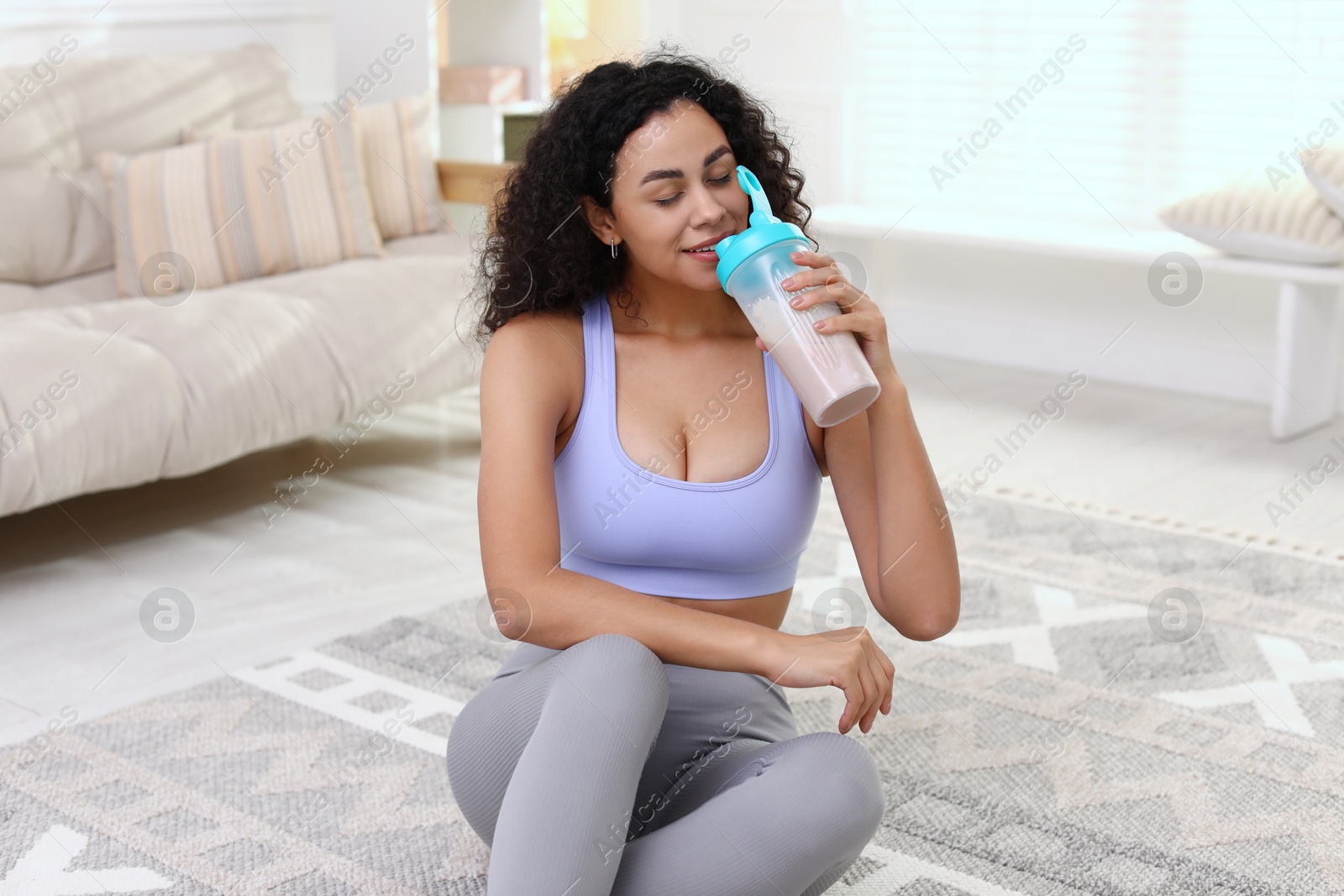 Photo of Beautiful woman drinking protein shake at home