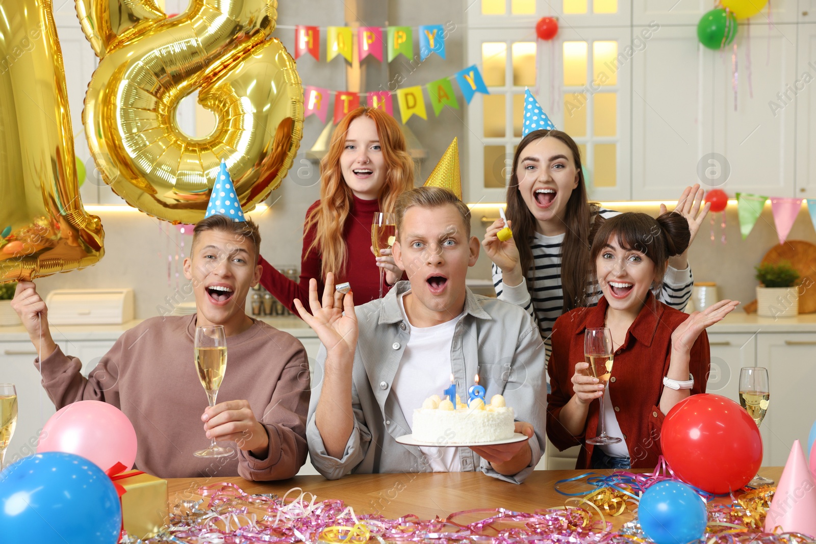 Photo of 18th birthday. Group of friends with tasty cake having coming of age party at home