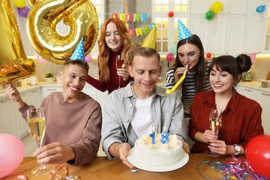 Photo of 18th birthday. Group of friends with tasty cake having coming of age party at home