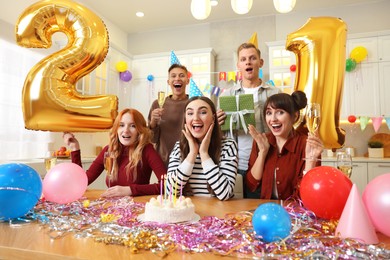 Photo of 21st birthday. Group of happy friends with tasty cake having coming of age party at home