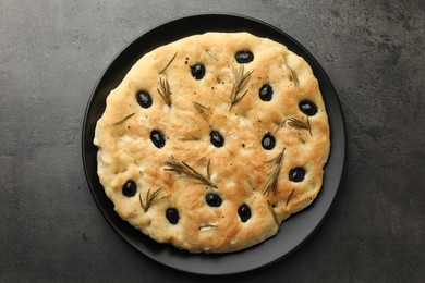 Photo of Delicious focaccia bread with olives and rosemary on grey table, top view