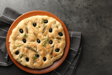 Photo of Delicious focaccia bread with olives and rosemary on grey table, top view. Space for text