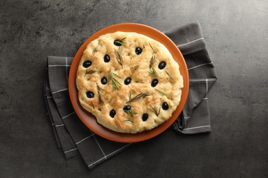 Photo of Delicious focaccia bread with olives and rosemary on grey table, top view