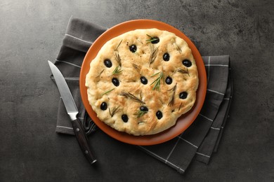 Photo of Delicious focaccia bread with olives, rosemary and knife on grey table, top view