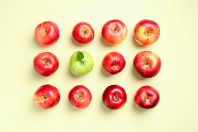 Red apples and green one on beige background, flat lay