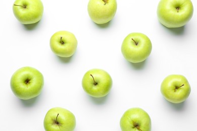 Green apples on white background, flat lay