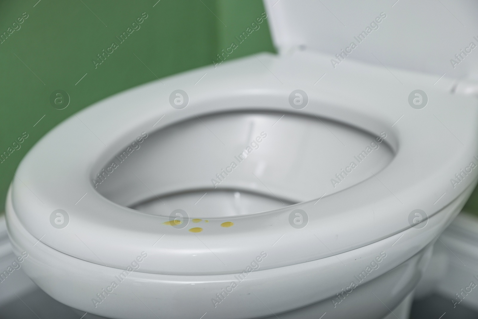 Photo of Urine drops on toilet seat in restroom, closeup