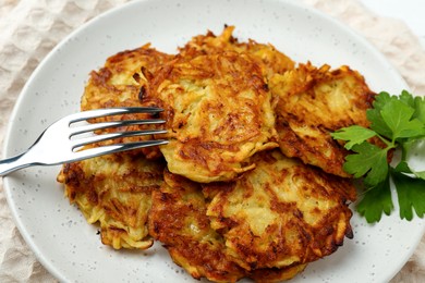 Photo of Delicious potato pancakes served on table, closeup