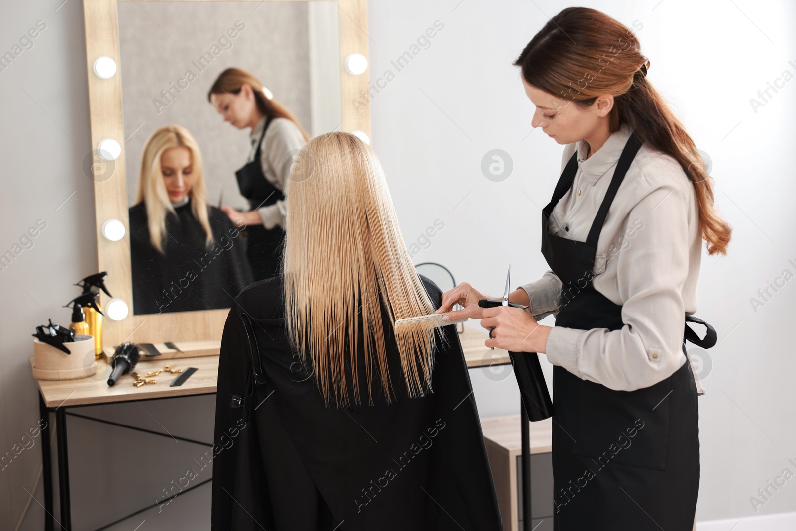 Photo of Hair cutting. Professional hairdresser working with client in salon