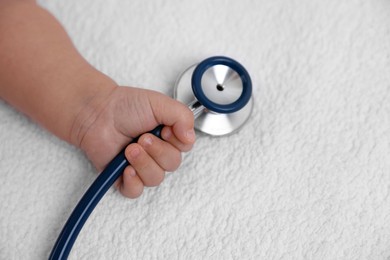 Photo of Little child with stethoscope on towel, space for text. Checking baby's health