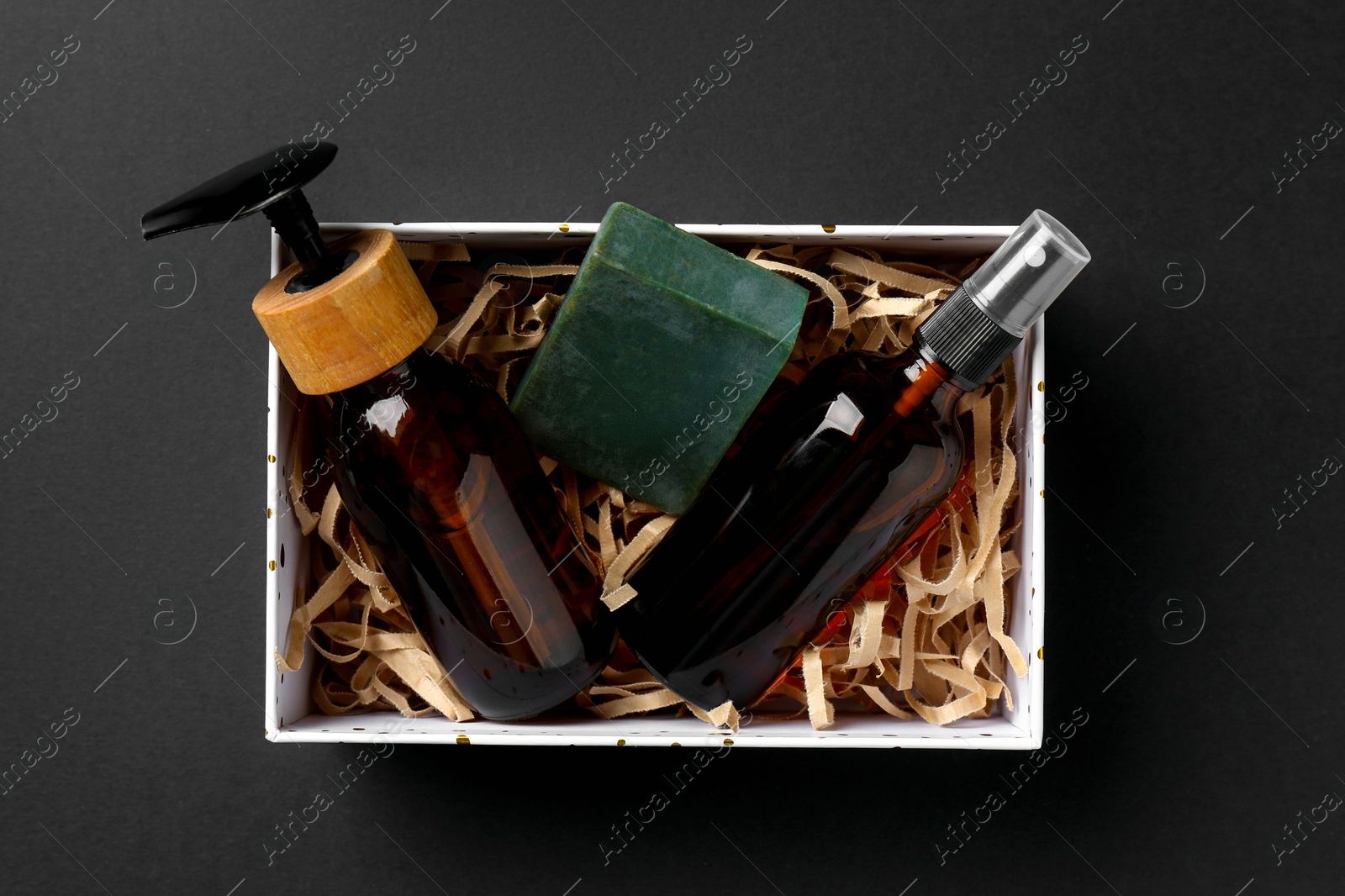 Photo of Cosmetic products in box as Christmas gift on black background, top view