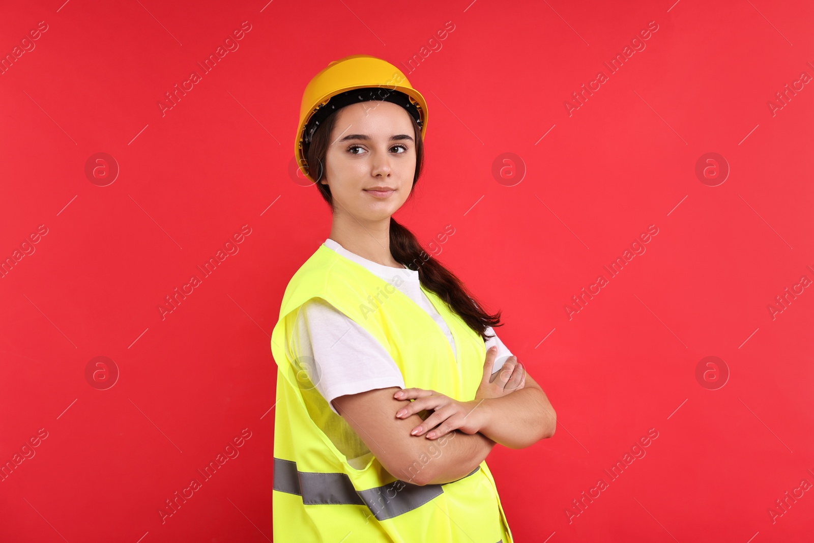 Photo of Girl with safety equipment on red background. Work for teenagers