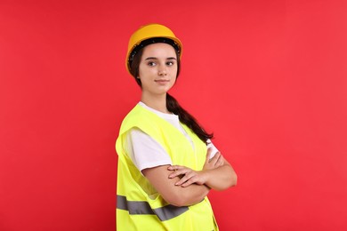 Girl with safety equipment on red background. Work for teenagers