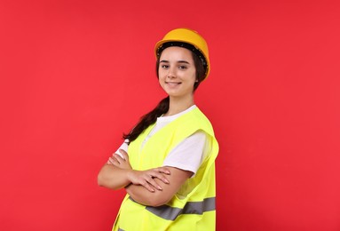 Photo of Girl with safety equipment on red background. Work for teenagers