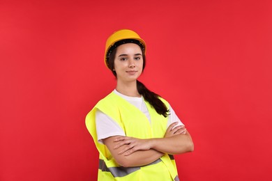 Photo of Girl with safety equipment on red background. Work for teenagers