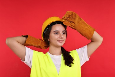 Photo of Girl with safety equipment on red background. Work for teenagers