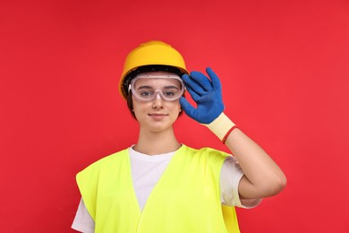 Photo of Girl with safety equipment on red background. Work for teenagers